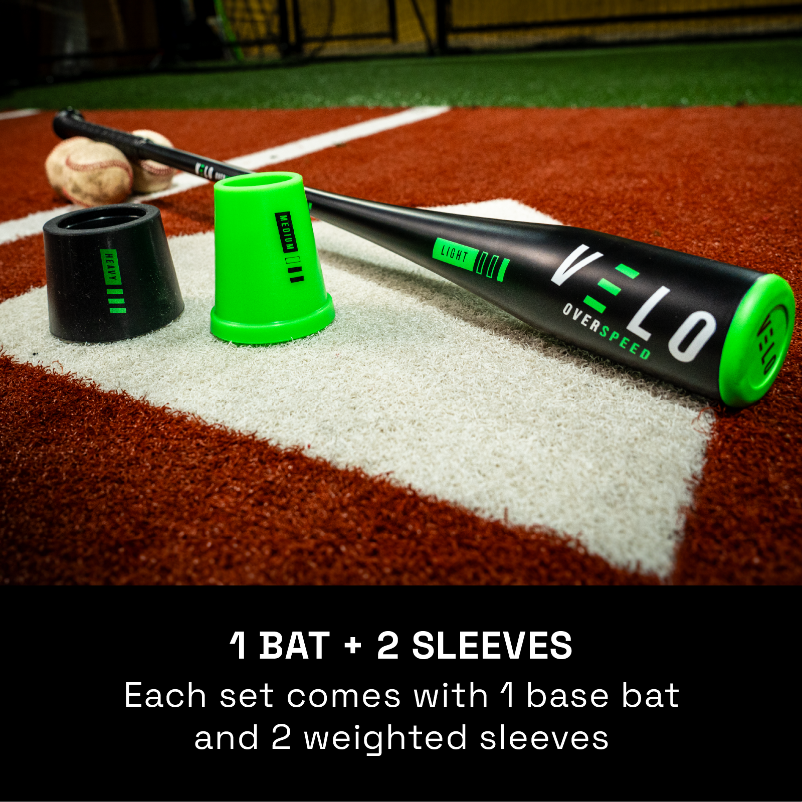 Black and green VELO Overspeed PRO training bat resting on artificial turf batters box with medium green weight and heavy black weight 