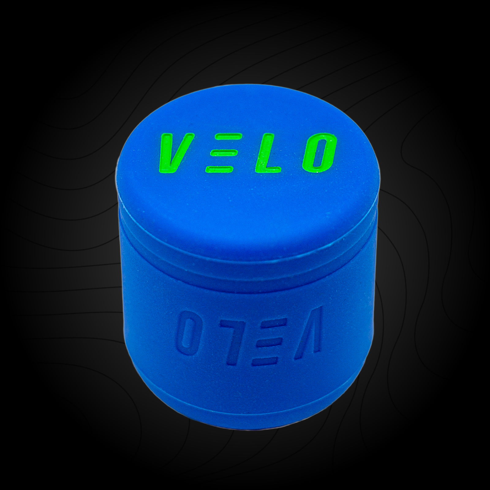 A blue VELO baseball puck knob attachment with the brand name 'VELO' written in green on the bottom surface.